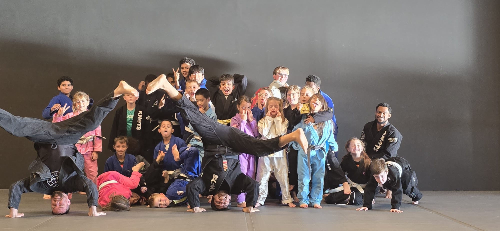 Fun group photo of kids and coach at Knots Jiu-Jitsu